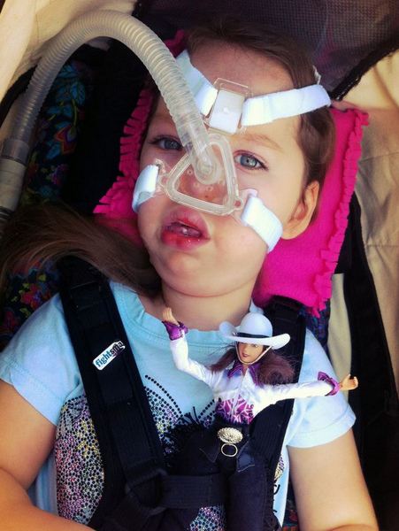Gwendolyn's daughter, wearing a breathing tube.