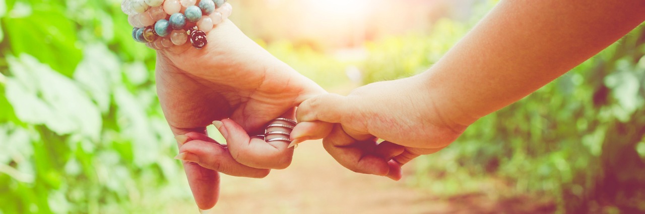 A Letter to a Friend With a Chronic or Invisible Illness Two people linking pinkies together in a field