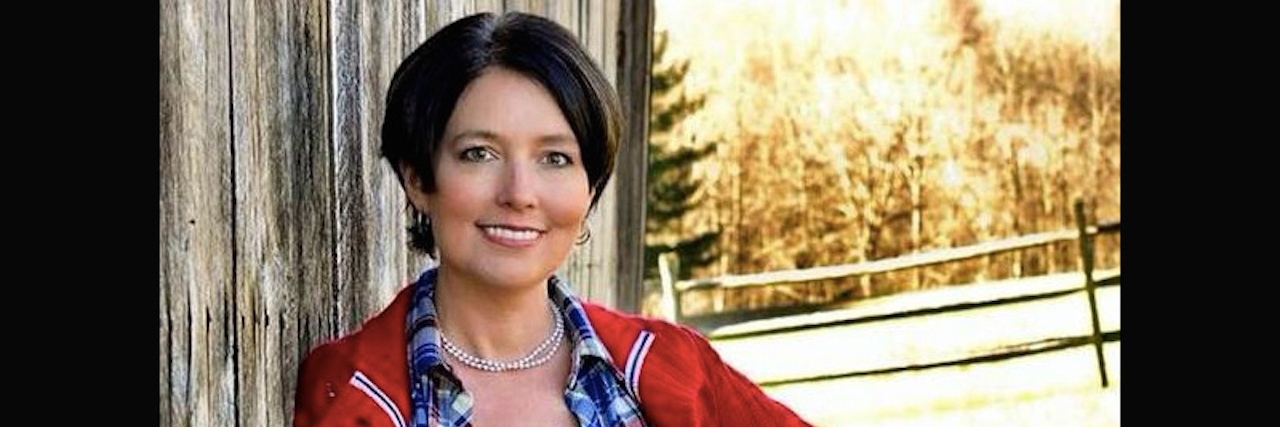 What It's Like to Live With Lyme Disease During the Holidays A young woman standing next to the side of a building