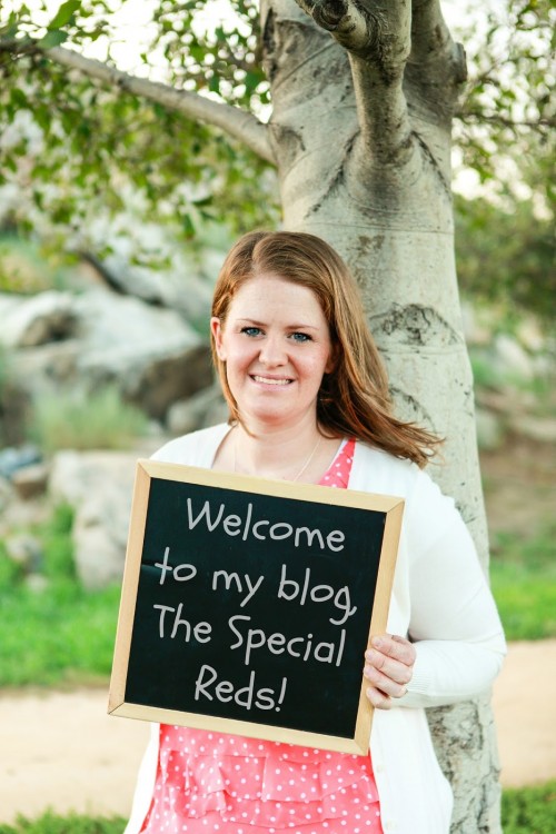 woman holding sign that reads 'welcome to my blog, The Special Reds!'