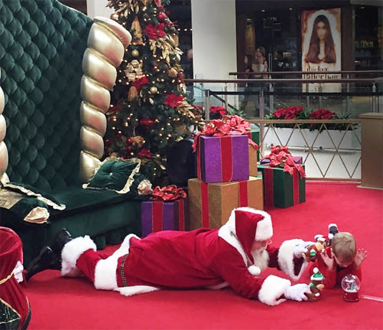 santa lays on the floor to play with boy with autism