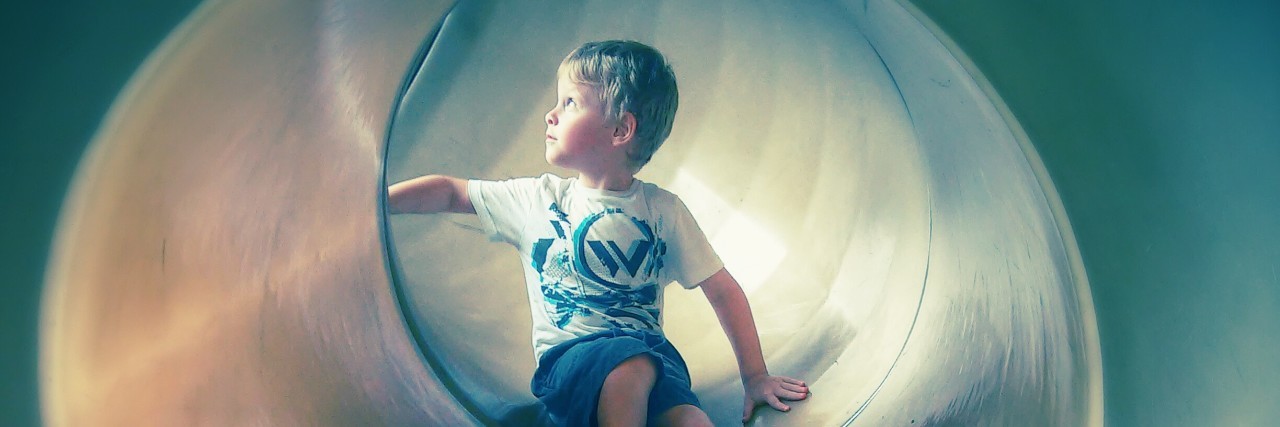 To the Mom of Twins on the Autism Spectrum little boy playing in a slide