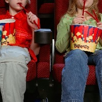 People eating popcorn at the movies.