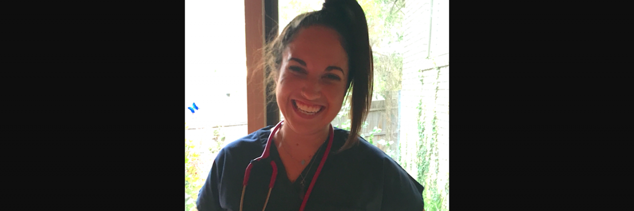 Nurse wearing scrubs and a stethoscope around her neck, smiling