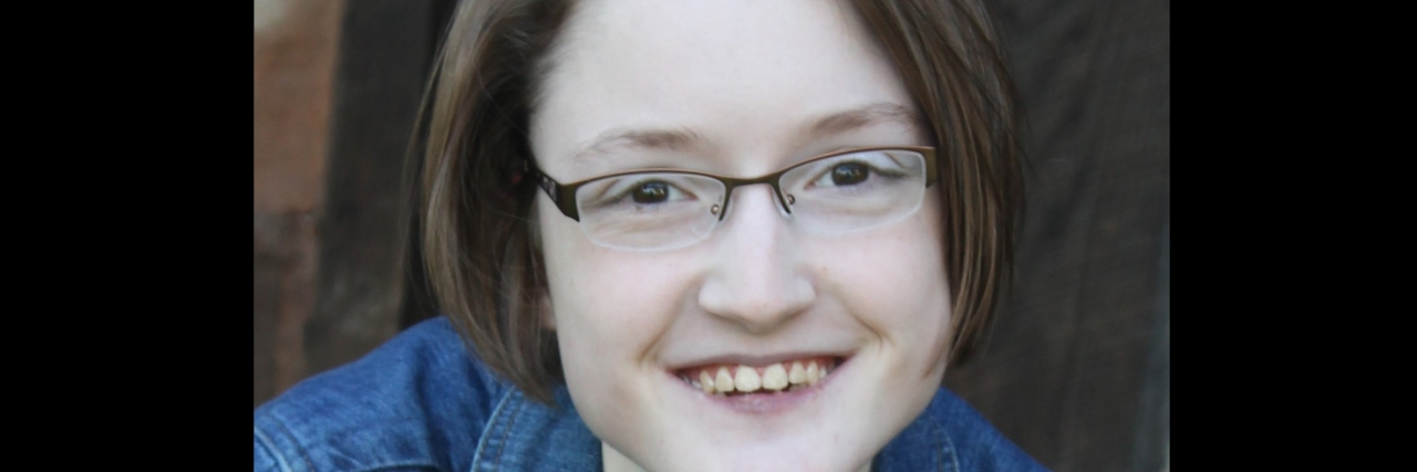 A smiling young woman with glasses