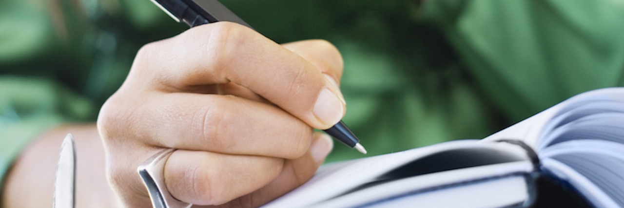 How to Set and Achieve Goals When You're Chronically Ill Woman writing in book