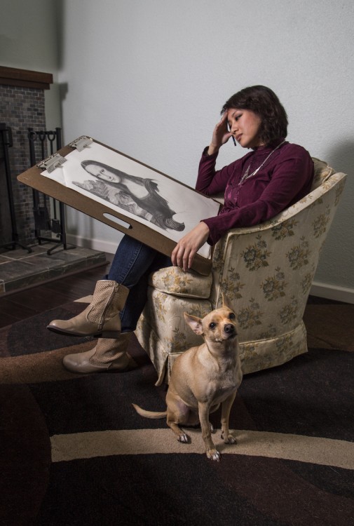 Woman holding a sketch with a dog by her side