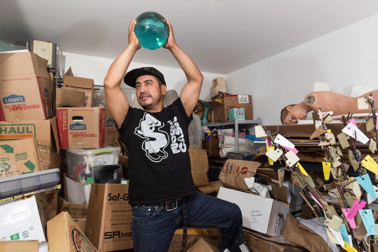 A man holds a sphere in a storage room