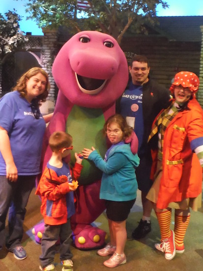 family posting for a photo with Barney the Dinosaur