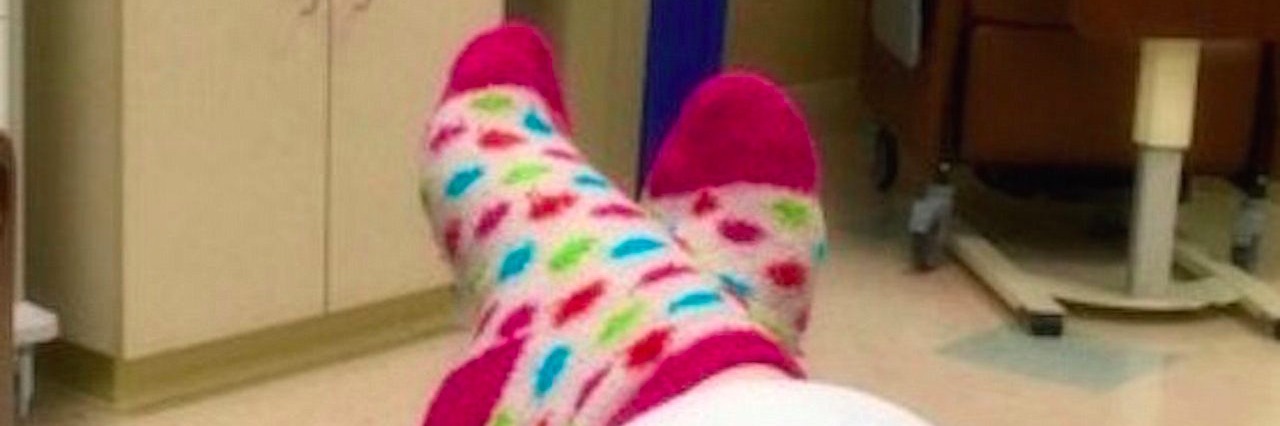 Hoping a Test Would Find Something Wrong With Me woman takes photo of her feet while lying in bed for a medical test