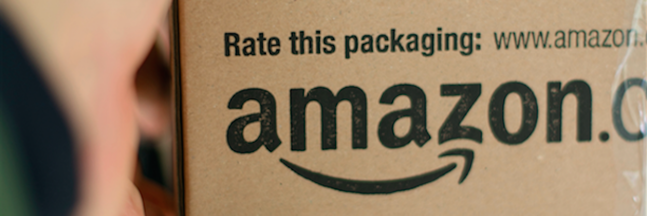 A person handing over an 'Amazon' box to a woman