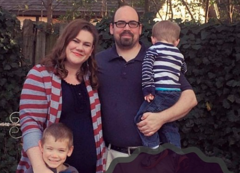 man and woman standing with two boys
