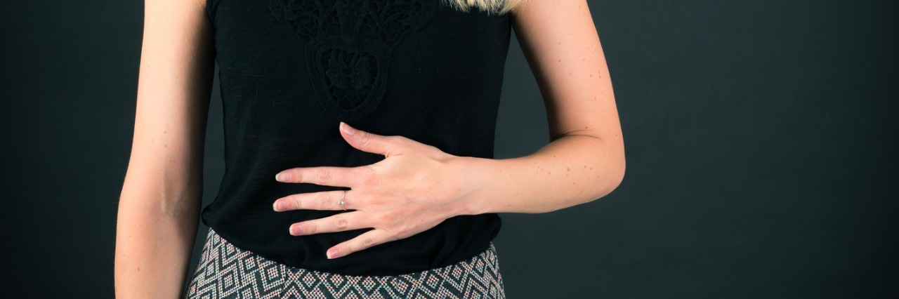 Why I Rub My Stomach Almost 24/7 woman rubbing her stomach