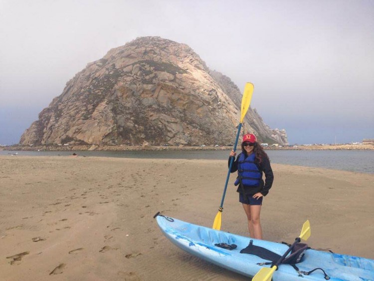 woman standing with kayak in front of rock