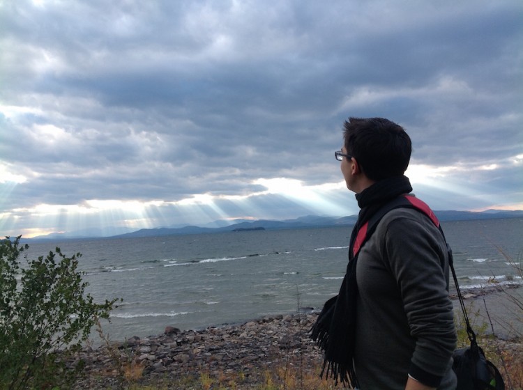 woman looking out at clouds and lake