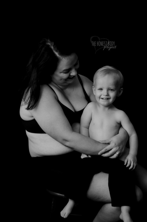 A mother hugs her son while seated