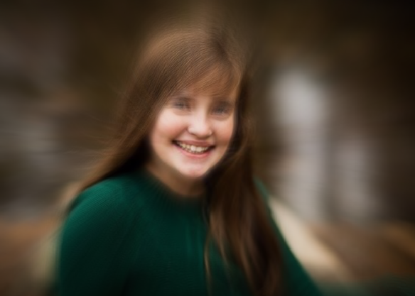 fuzzy photo of girl in green sweater