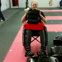 A woman in her wheelchair with something on her lap