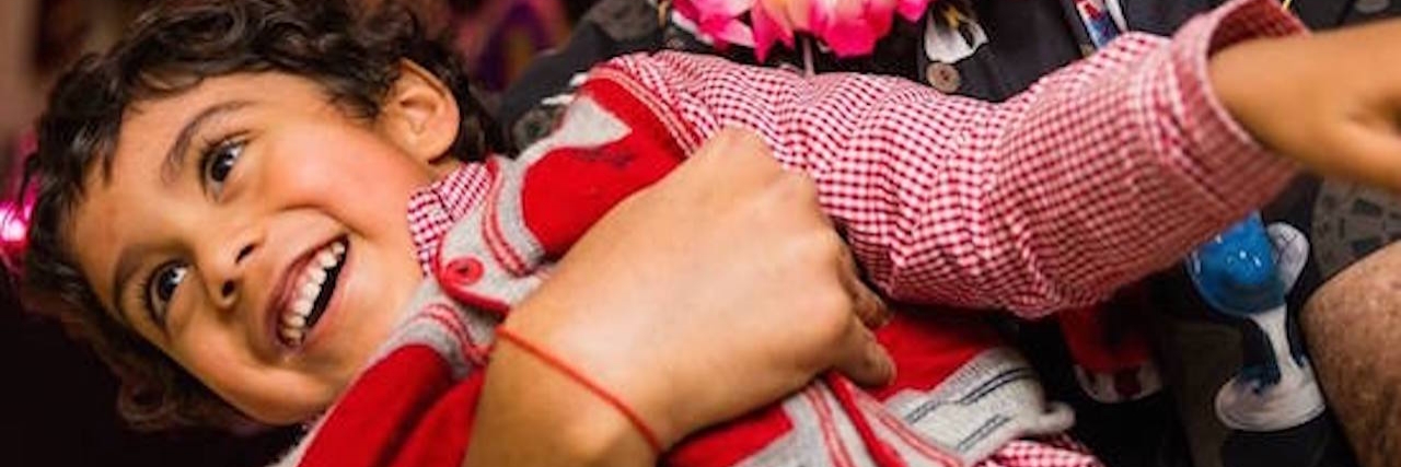 The Realities That Face a Cancer Survivor After the Cancer Is Gone A man laughing and holding a small boy in his arms