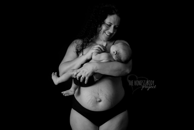 A smiling mother cradles her infant