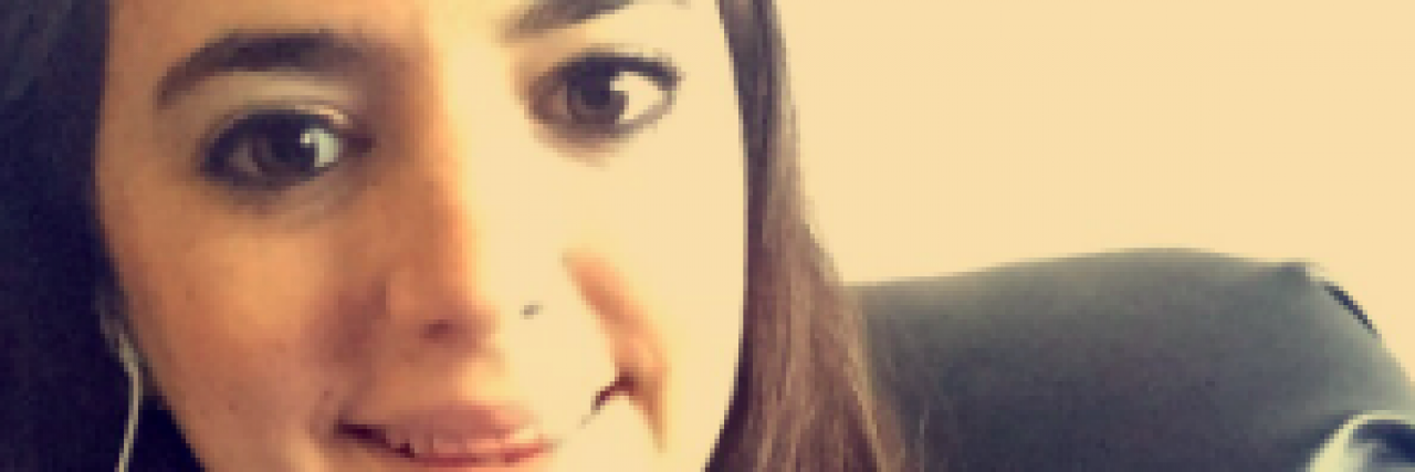 The Awkward Question I Wish My Loved Ones Wouldn't Ask About My Chronic Illness Woman with wired headphones smiling