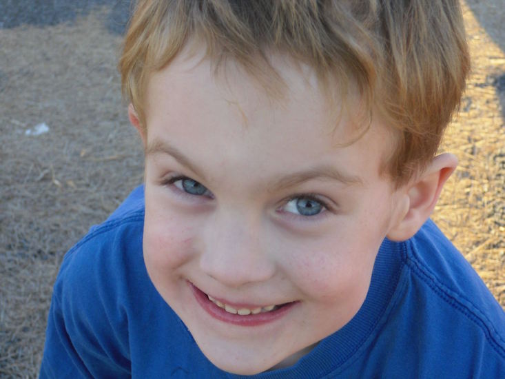 little boy smiling and wearing a blue shirt