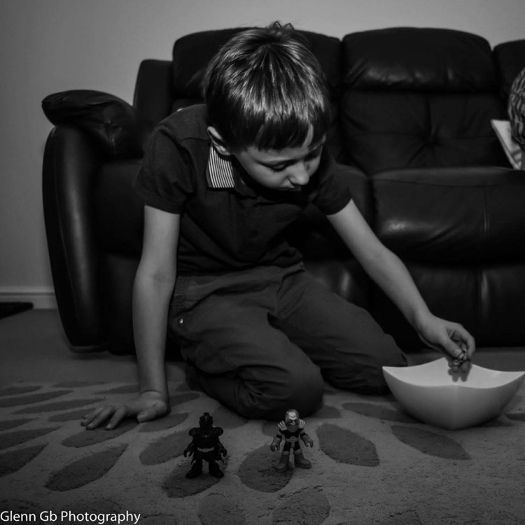 A boy playing on the floor with toys. 