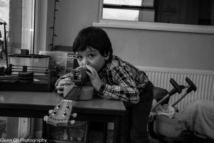 A young boy playing with a musical instrument. 