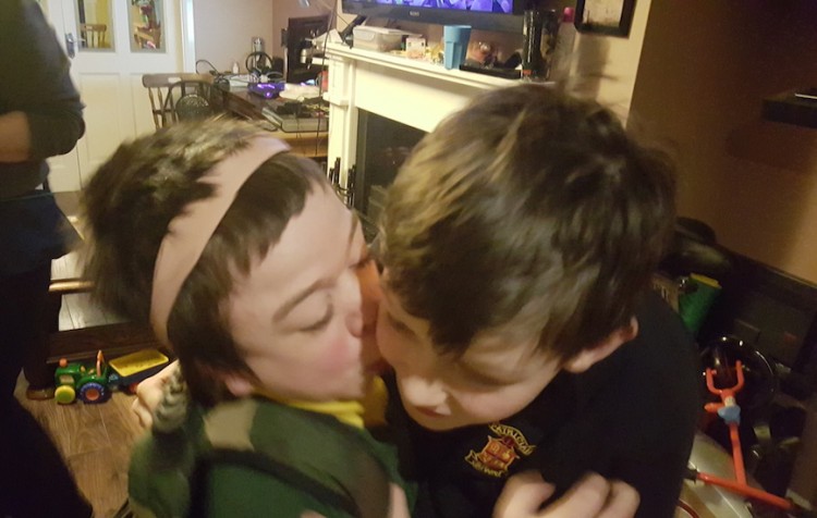 boy kissing his brother on the cheek
