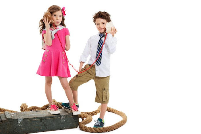 Two children, one with a limb difference, wearing adaptable clothing