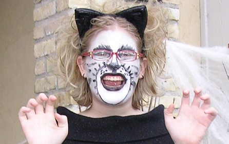 Woman with her face painted as a cat and wearing cat ears
