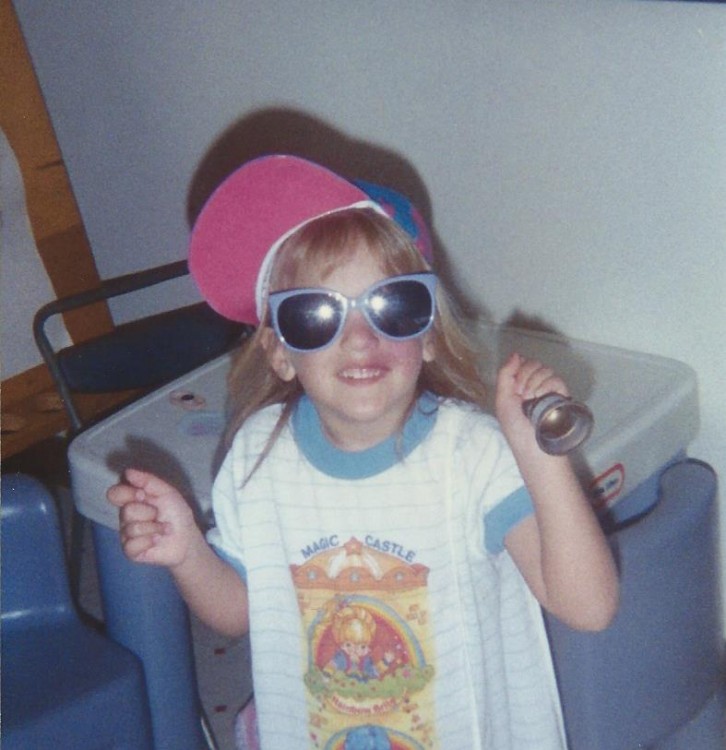 little girl wearing sunglasses indoors