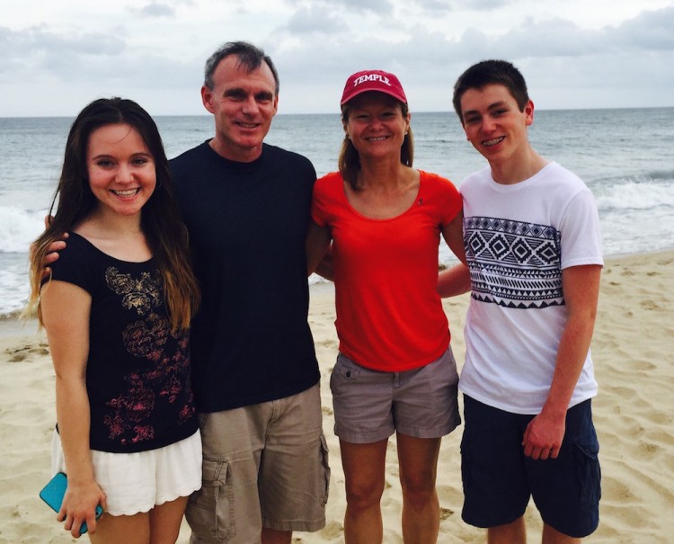 man, woman, teenage boy and teenage girl on the beach