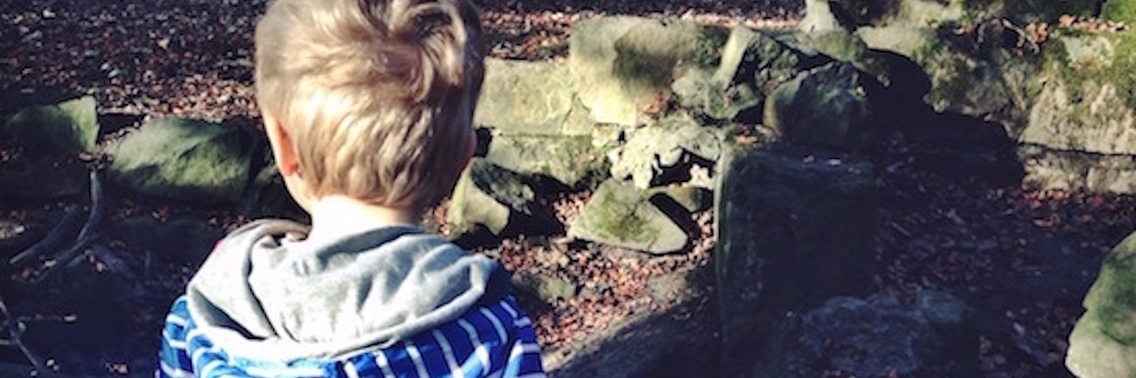 Why I Wouldn't Take Away My Son's Autism Boy in striped blue and white hoodie standing outdoors