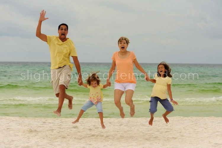 family jumping on beach