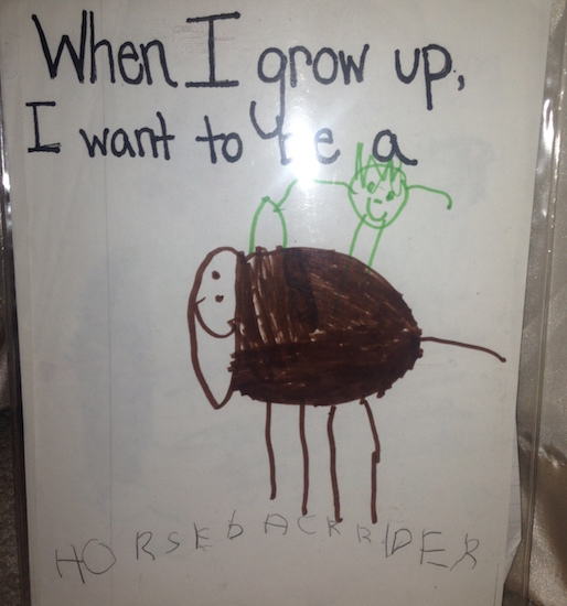 Child's drawing of person riding horse. It says "When I grow up, I want to be a horseback rider."