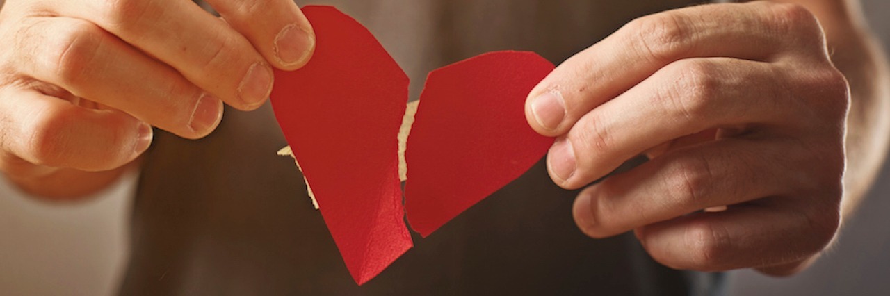Getting Told 'It Could Be Worse' as Someone With PTSD hands holding a ripped paper heart