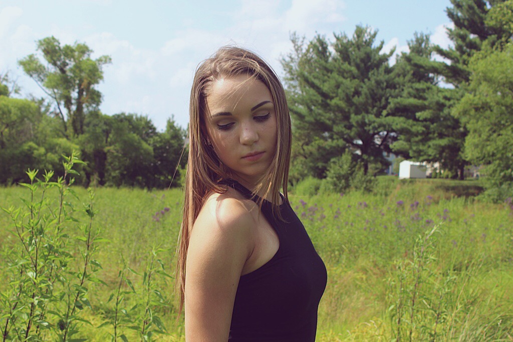 woman standing outdoors with a grassy landscape