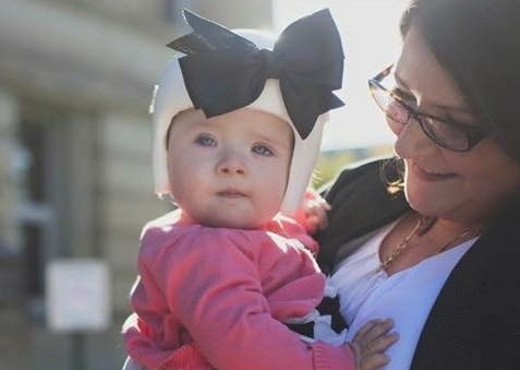 girl with boy on head held by mom