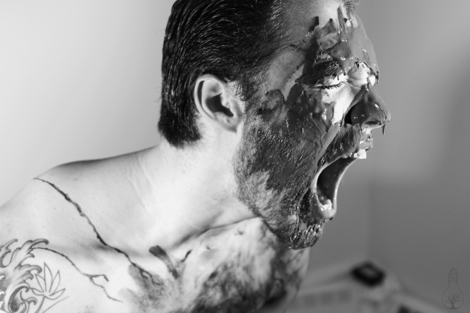 Man screaming, with black all over his face.