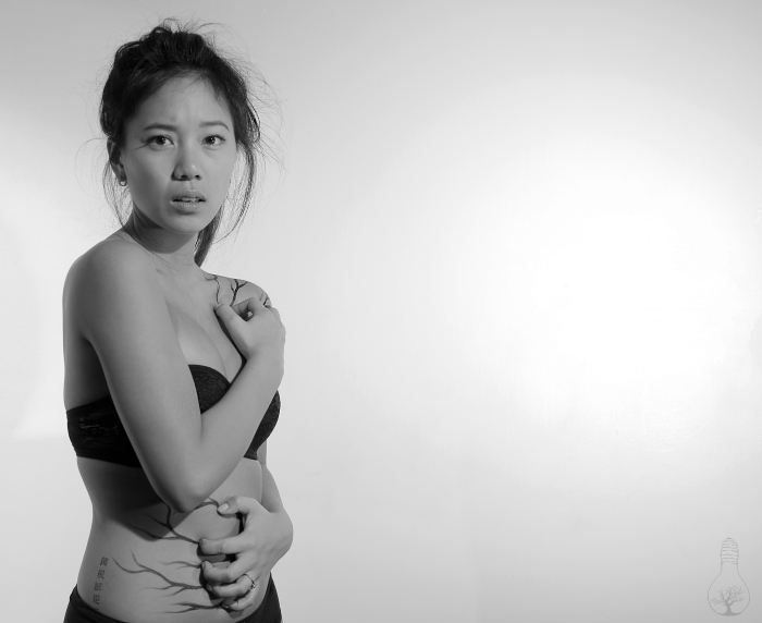 Woman staring into the camera with black streaks on her belly.