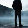 Silhouette of person standing on a dock in the mist