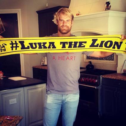 Greg Olsen holding a Luka The Lion scarf