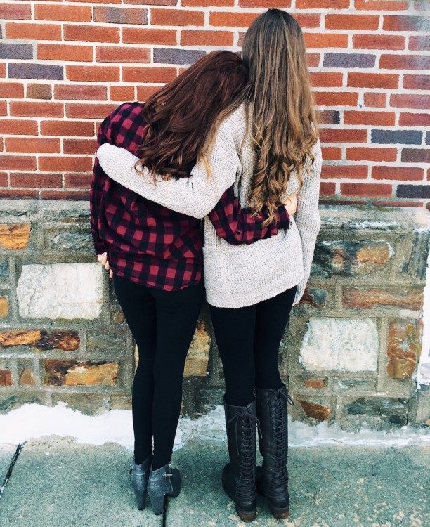 back view of two women with arms around each other