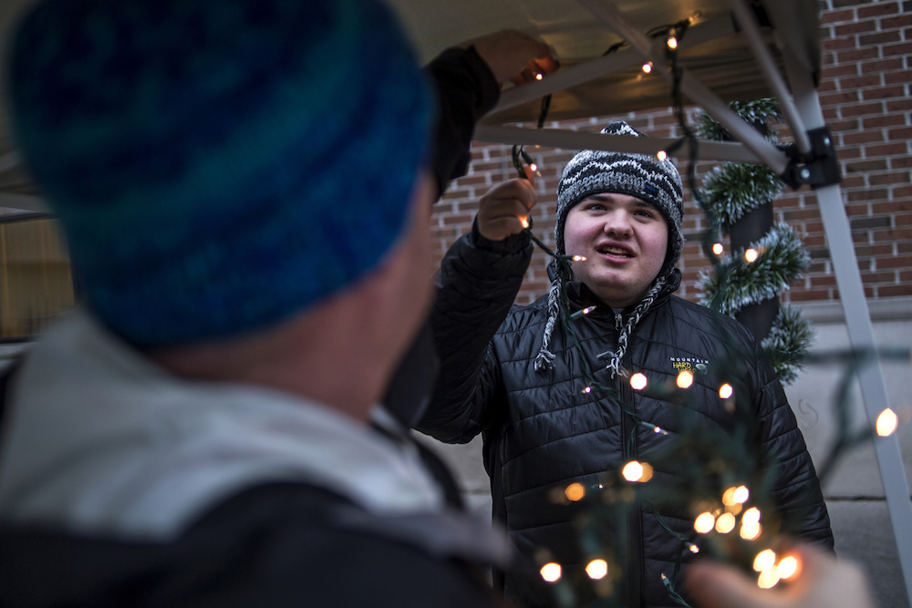 Dennis Mashue, left, strings lights though their booth at Midland's Winter Village as son Tucker Mashue, 17, right, helps on Dec. 17. Together Dennis Mashue and his son Tucker Mashue, 17, run Tuck's Tooques, a pro-autism microbusiness, which helps Dennis teach Tucker entrepreneurship skills by selling handmade Nepalese winter hats.