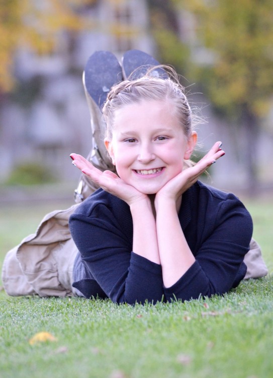 girl lying on her stomach on grass