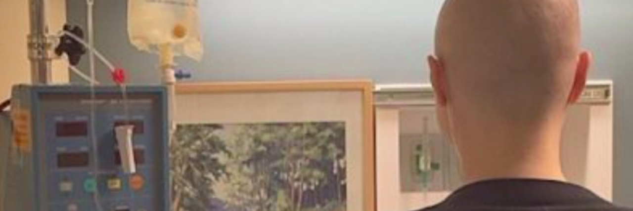 Rare Disease: Please Stop Saying ‘At Least It’s Not Cancer' Back view of woman without hair connected to medical equipment and looking at painting
