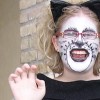Woman with her face painted as a cat and wearing cat ears