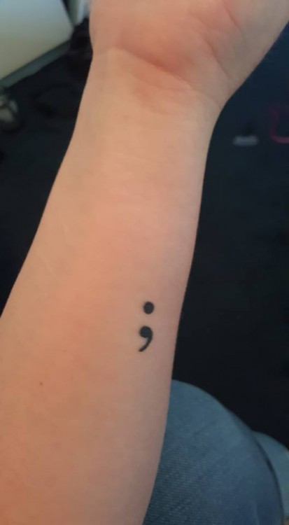 semi-colon tattoo on an arm