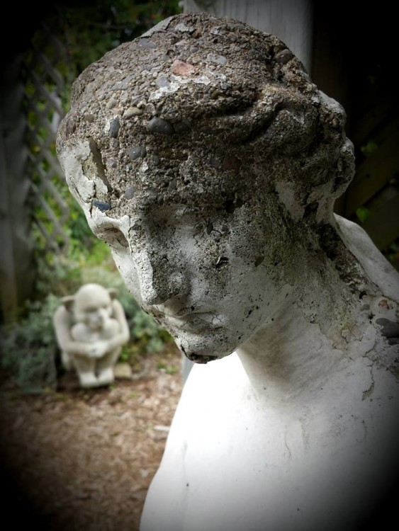 A stone woman. Pieces of her head are crumbling.